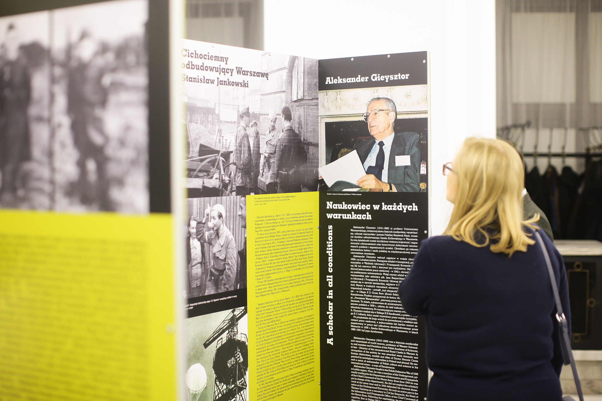 KI generiert: Auf dem Bild betrachtet eine Person eine Ausstellung, die Informationstafeln mit Texten und Bildern zum Thema Geschichte zeigt. Der Fokus liegt auf den ausgestellten Inhalten und dem Betrachter.