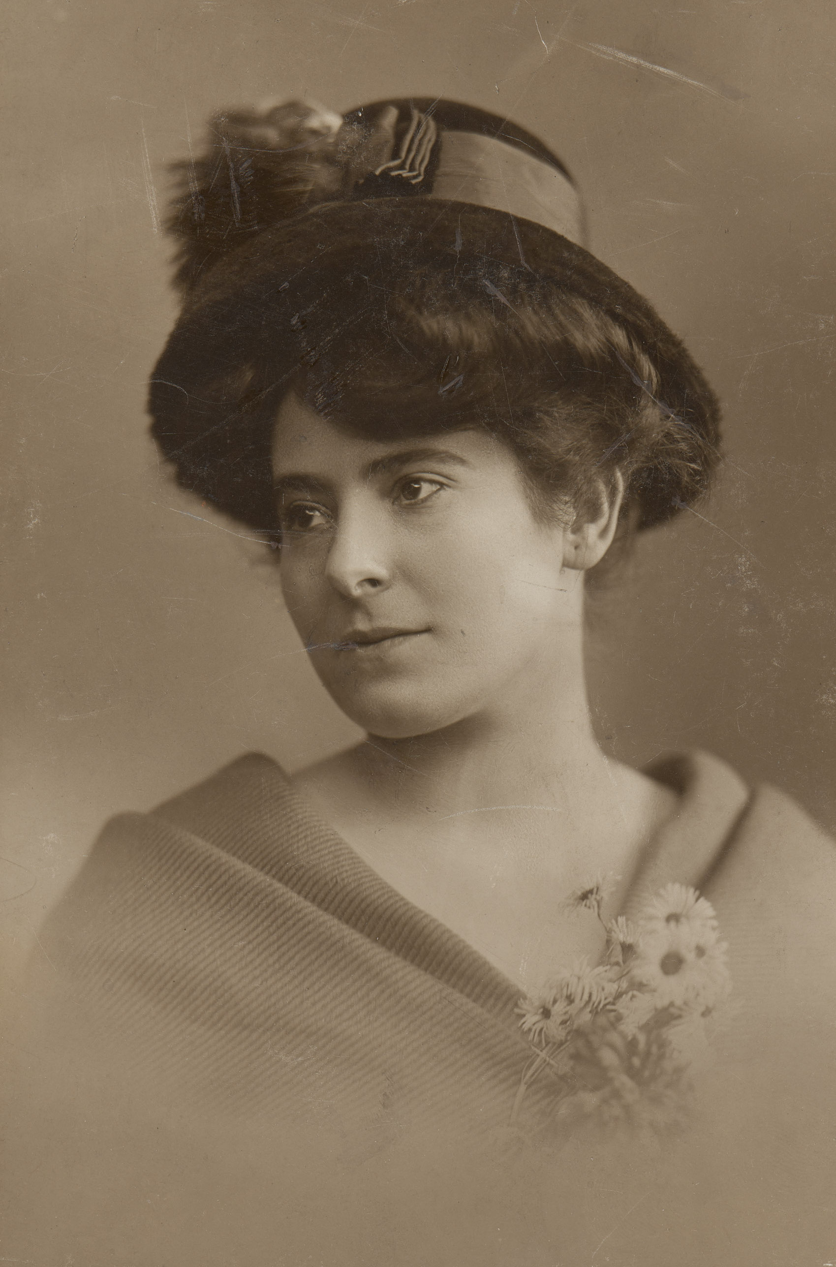 AI generated: The image shows a woman in a historical portrait, dressed in a hat and a cloak or scarf, while looking to the side. She is holding a small bouquet of flowers in her hand.